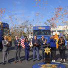 Chief probation officer and dignitaries launch confetti cannons at a press conference for new mobile resource vehicles